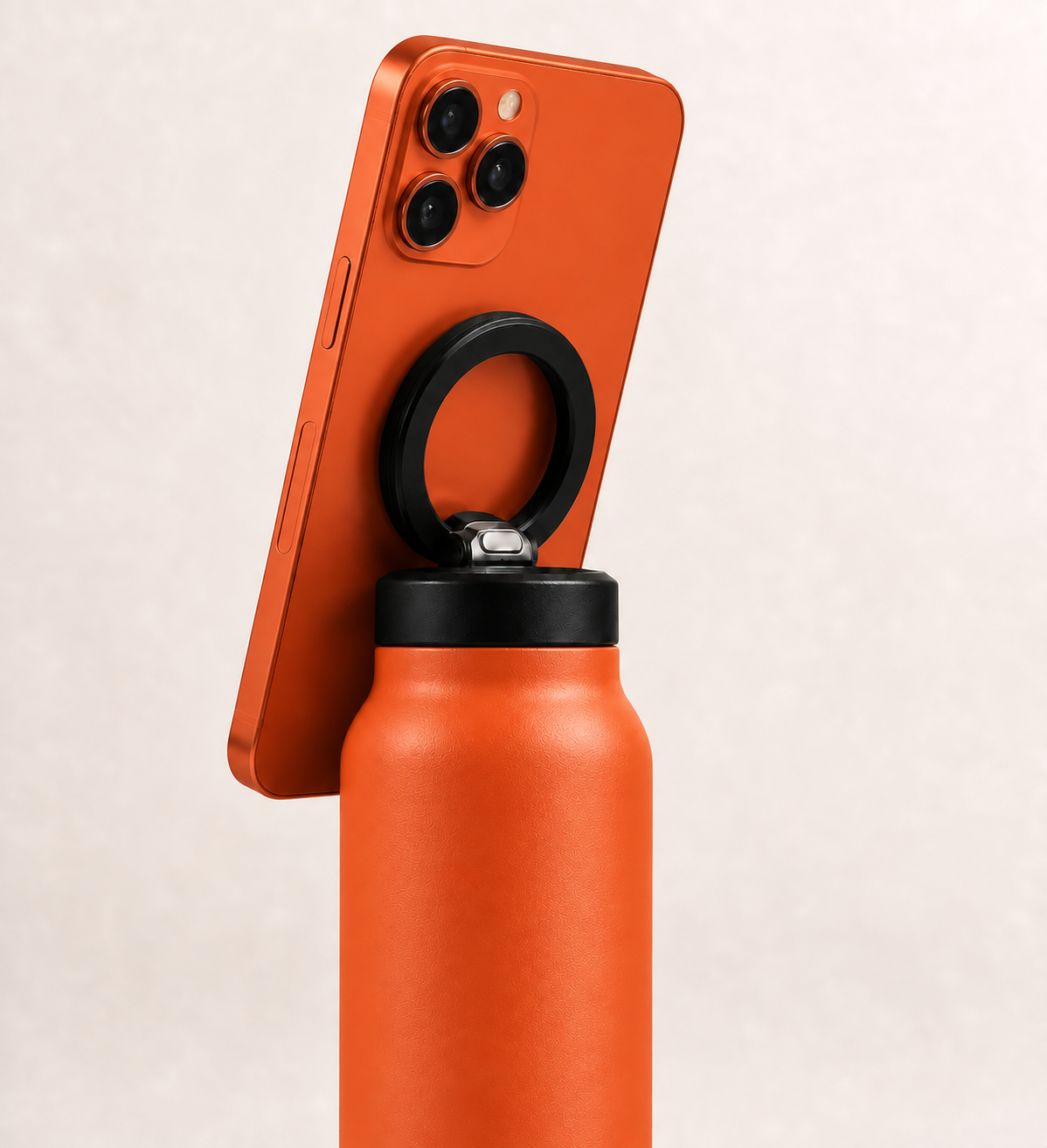 Solar Orange i Sheesh bottle holding a matching orange phone with the black ring magnet